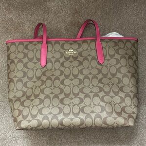 Coach SIG CITY tote with pink detail and straps.